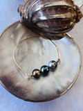 Three ringed Tahitian pearls on a gold-filled bangle—vibrant, luminous, and uniquely Tahitian.