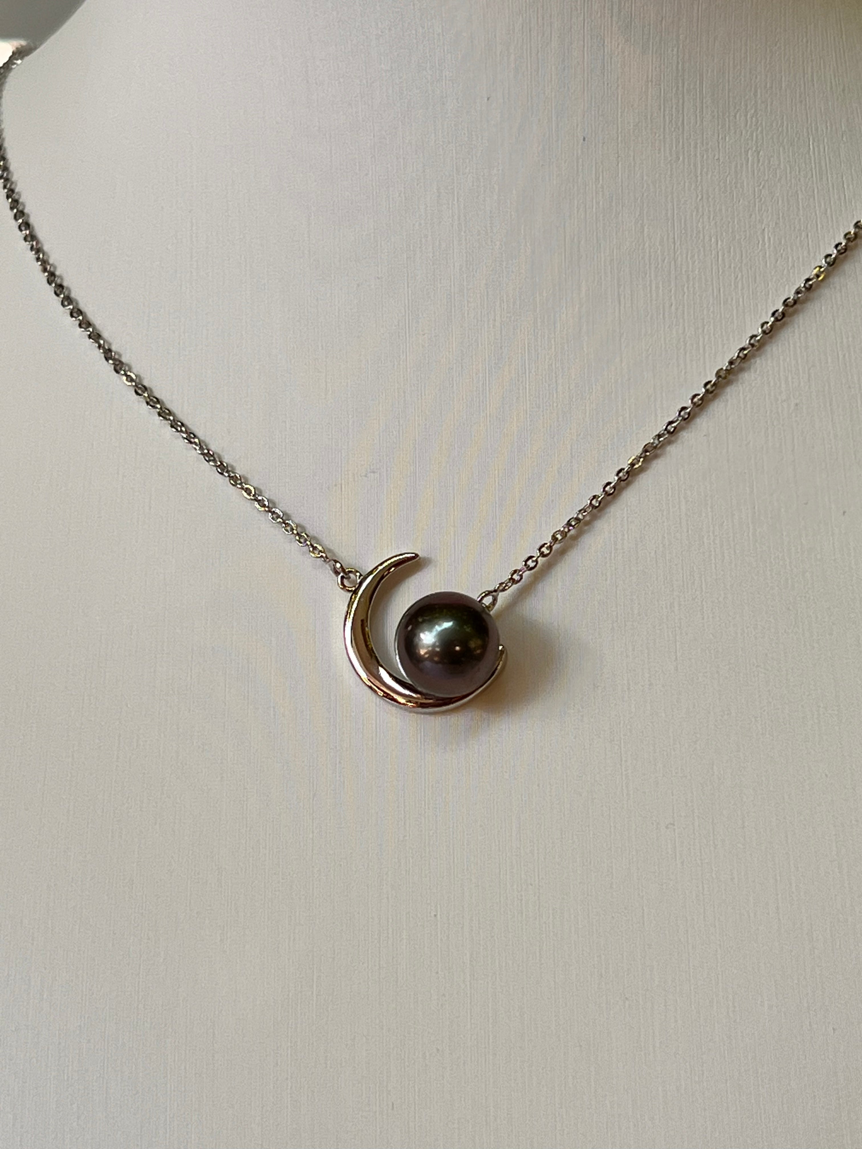 Rhodium-plated silver necklace featuring a unique moon-inspired design, set with a Tahitian pearl. Elegant and timeless.