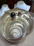 Authentic Tahitian black pearl on a sterling silver bangle, with a charming heart detail.